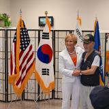 Congresswoman Lee with shaking hands with veteran