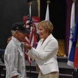 Rep. Susie Lee pinning a Vietnam Veteran