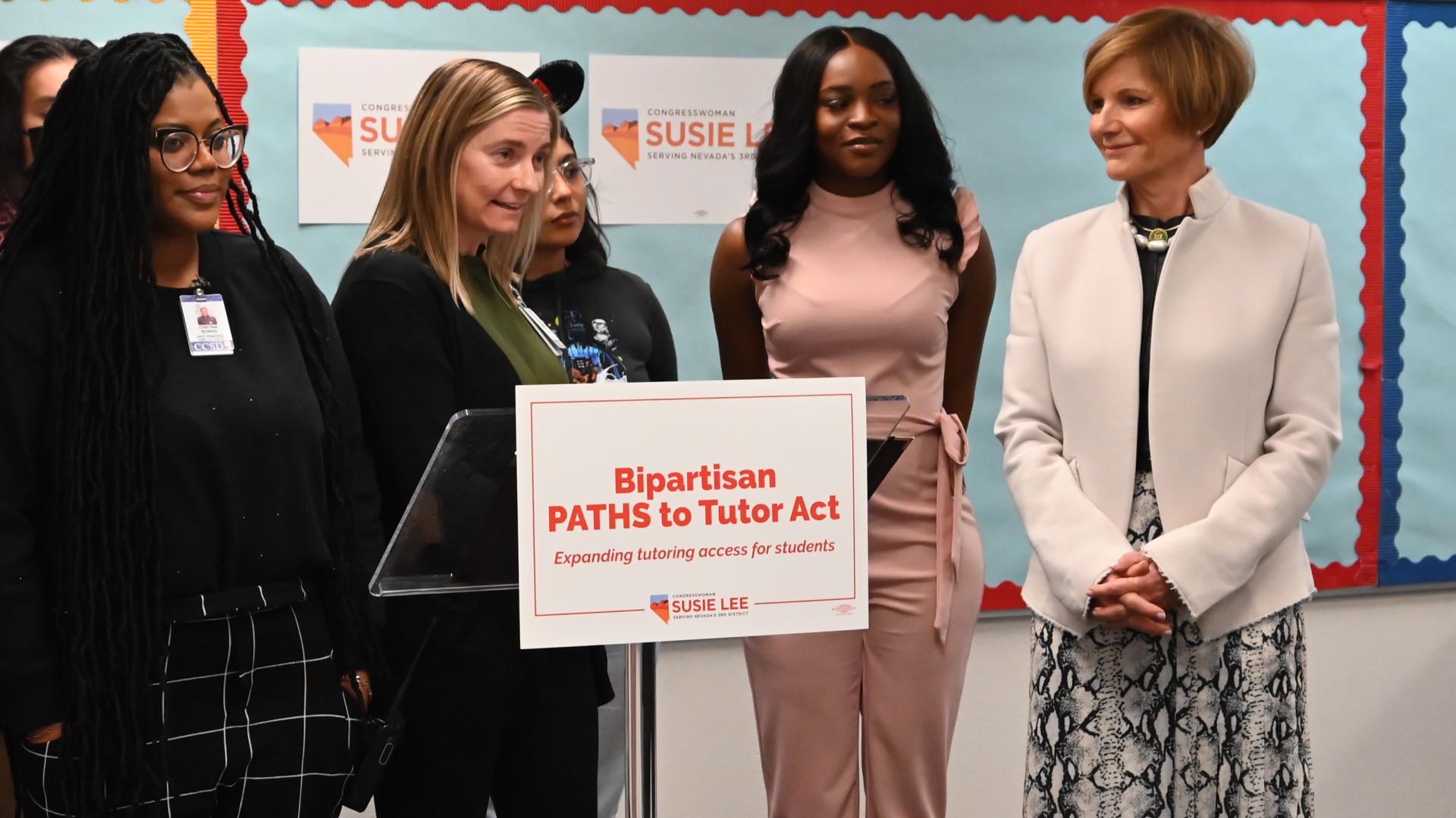 Congresswoman Lee standing beside podium at press conference